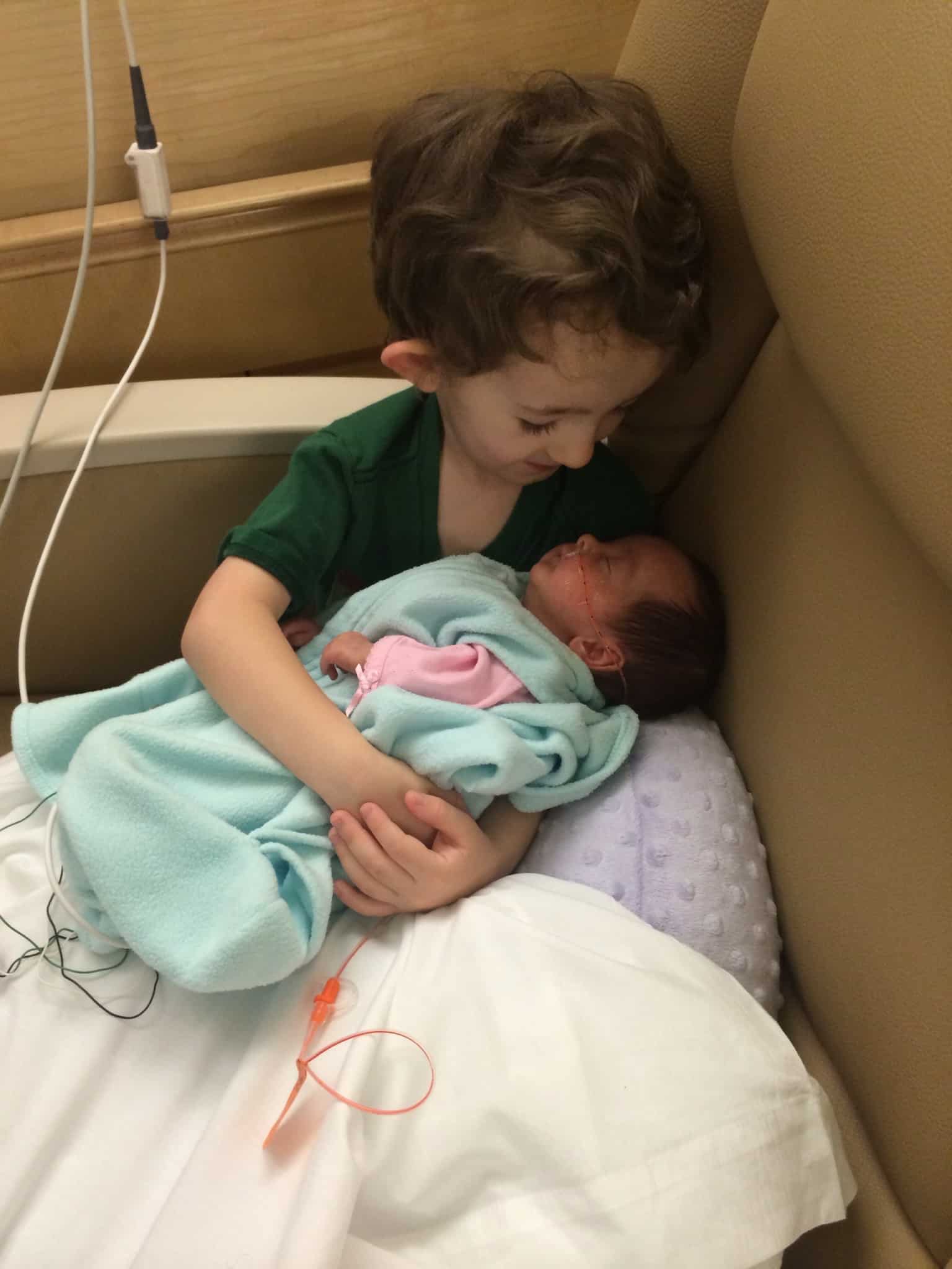 Little boy holding newborn
