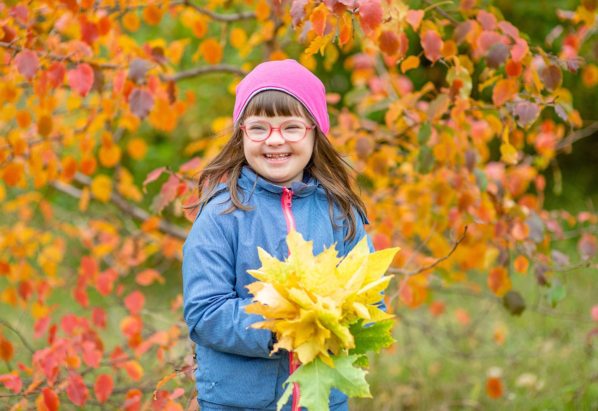Little girl holding flowers in the fall