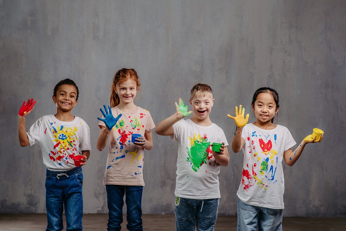 Group of kids with paint on their hands smiling